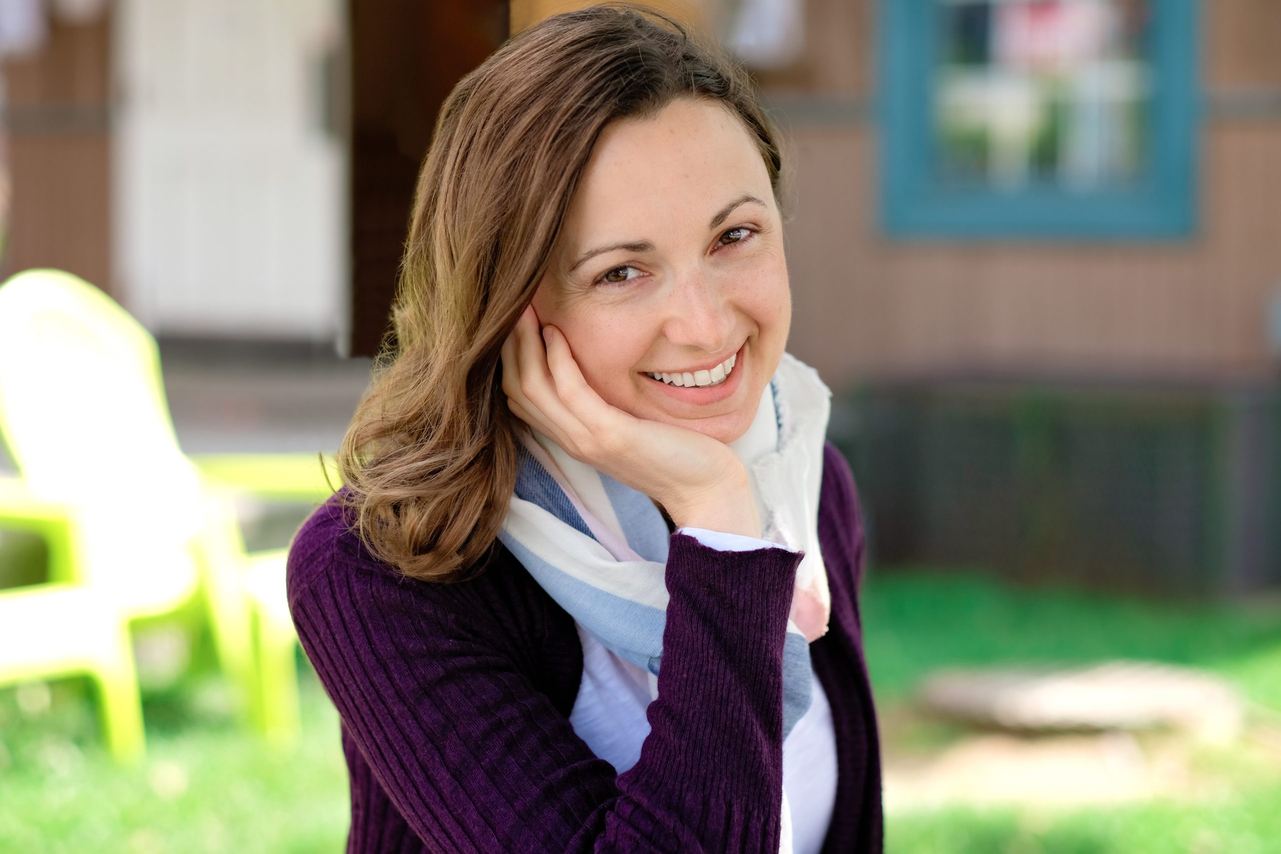 Lori Straus smiling at the camera, resting her chin on her hand.